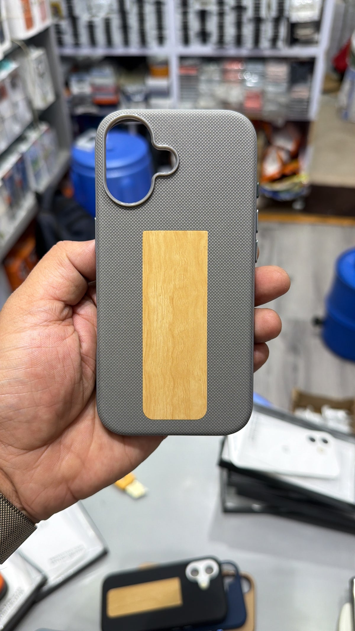 Grey diamond-textured MagSafe case with wood-grain finish panel and camera ring