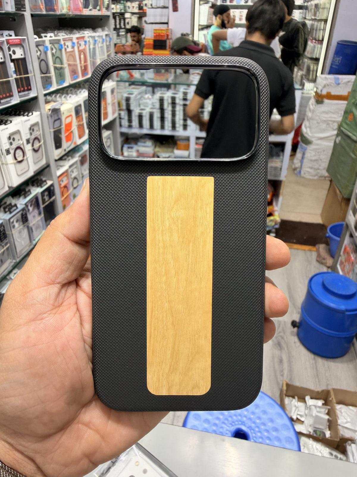 Wood panel textured MagSafe case in Black, held in hand