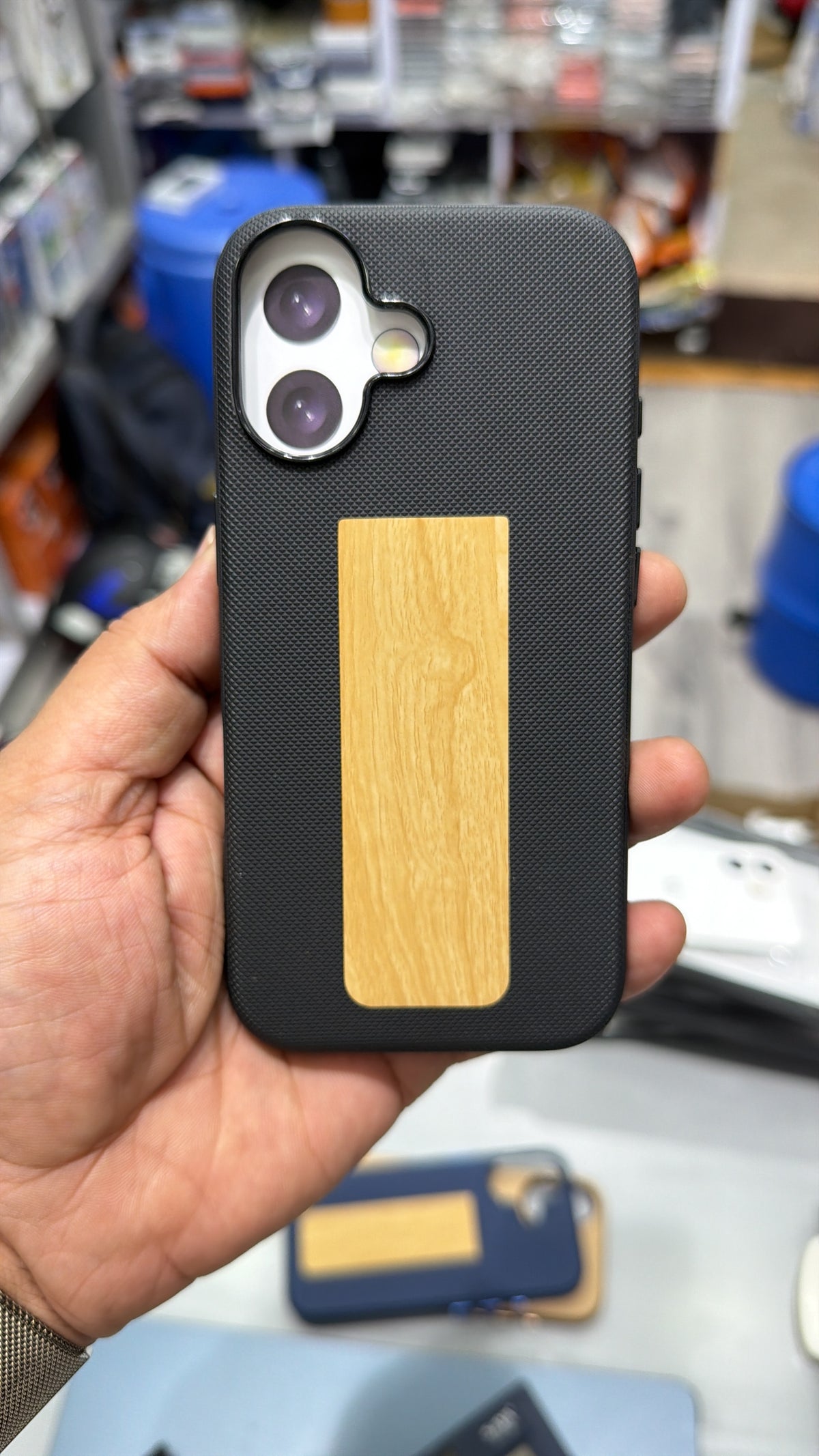 Black diamond-textured MagSafe case with wood-grain finish panel and camera ring